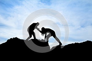 Silhouette of helping hand between two climber